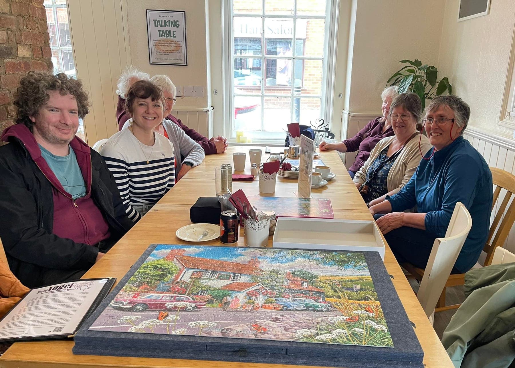 A group around the Talking Table working on a jigsaw together over drinks